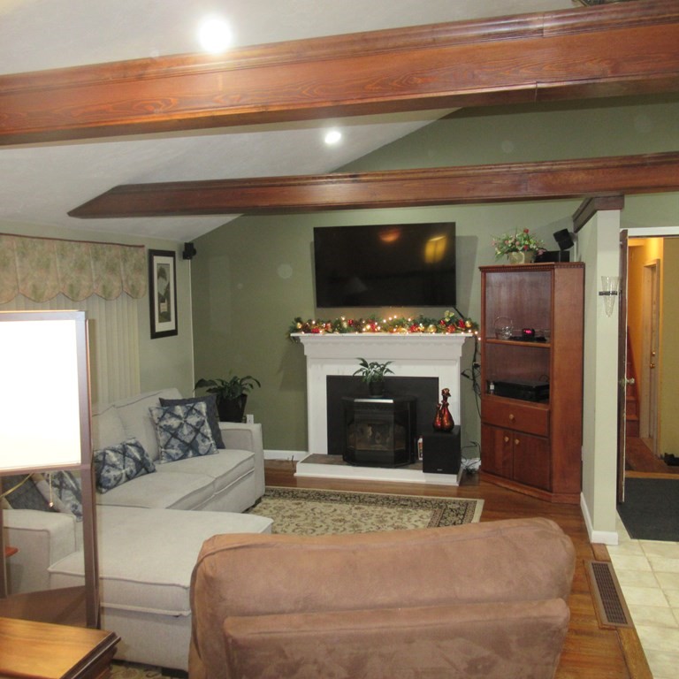 19 Haskell Road Pepperell, MA 01463 - Photo 14 of 40 a living room with furniture a flat screen tv and a fireplace
