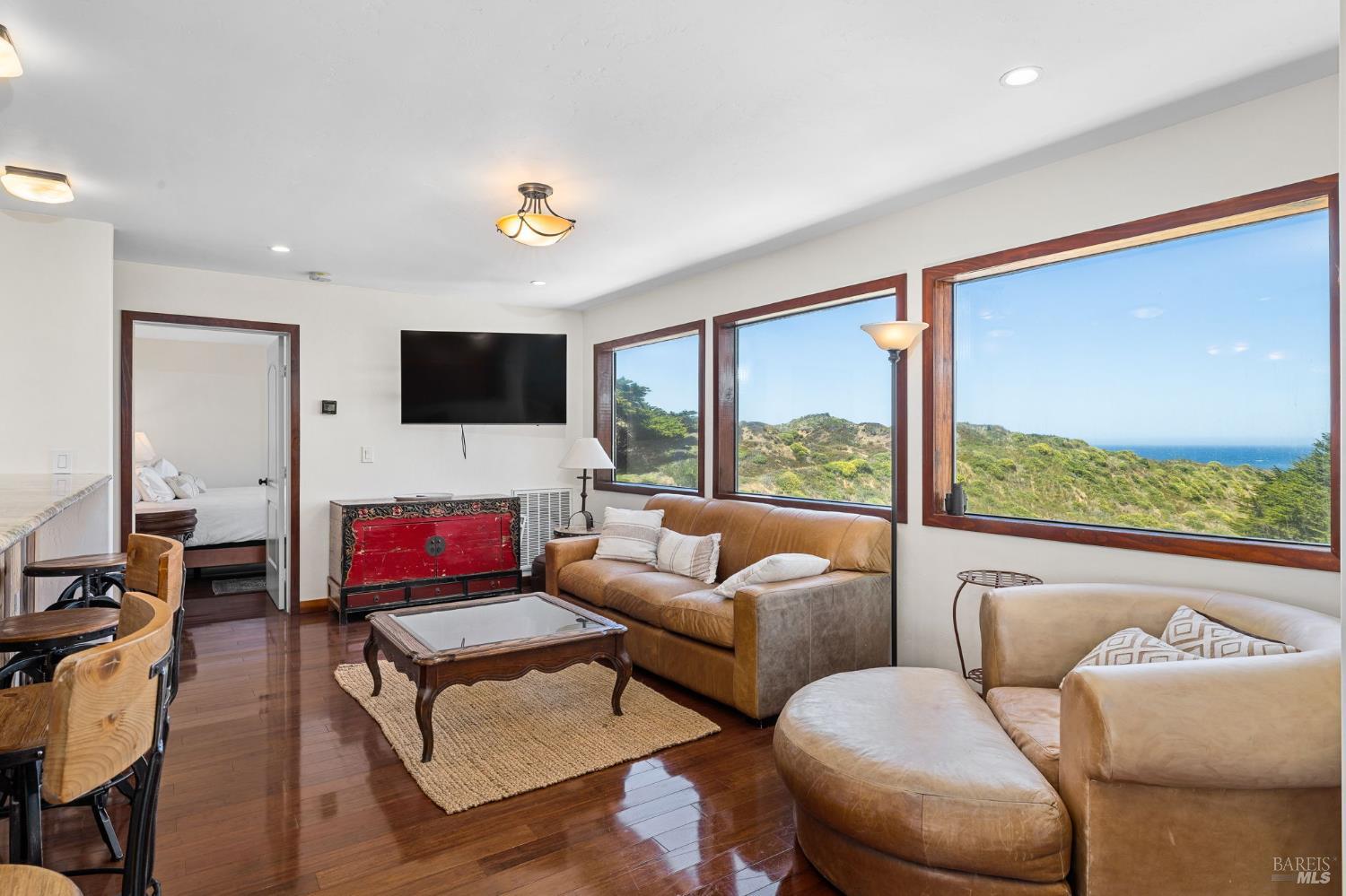 1846 Whaleship Road Bodega Bay, CA 94923 - Photo 24 of 69 a living room with furniture a flat screen tv and a floor to ceiling window