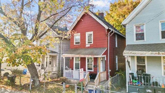 a view of a brick house with large windows and a tree