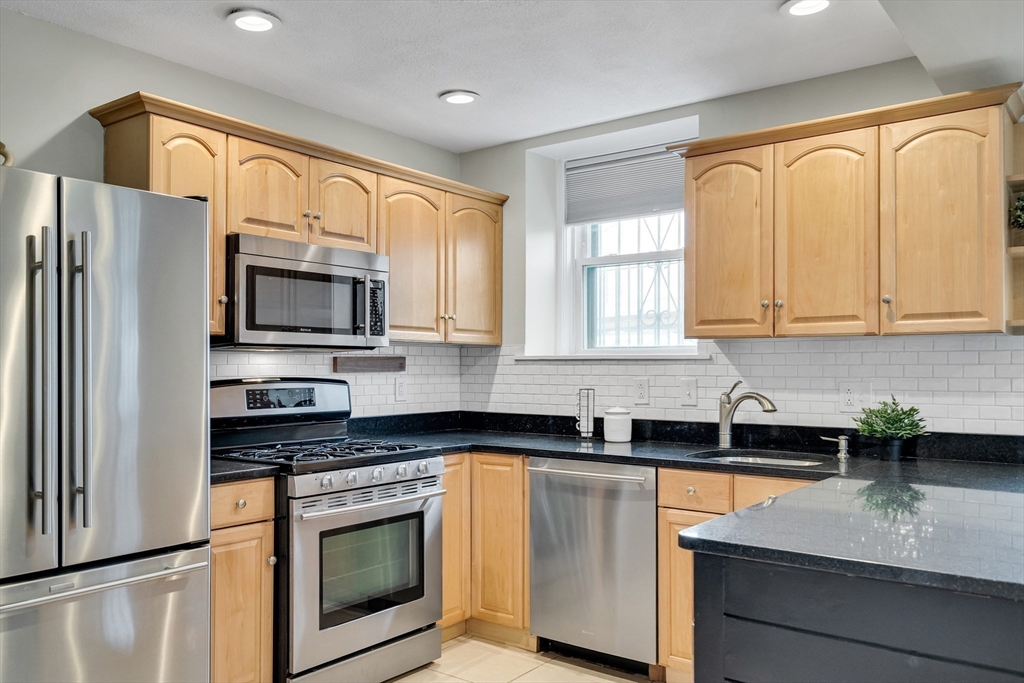 60 Charlesgate West, Unit BA Boston, MA 02215 - Photo 15 of 37 a kitchen with stainless steel appliances granite countertop white cabinets sink and a granite counter top