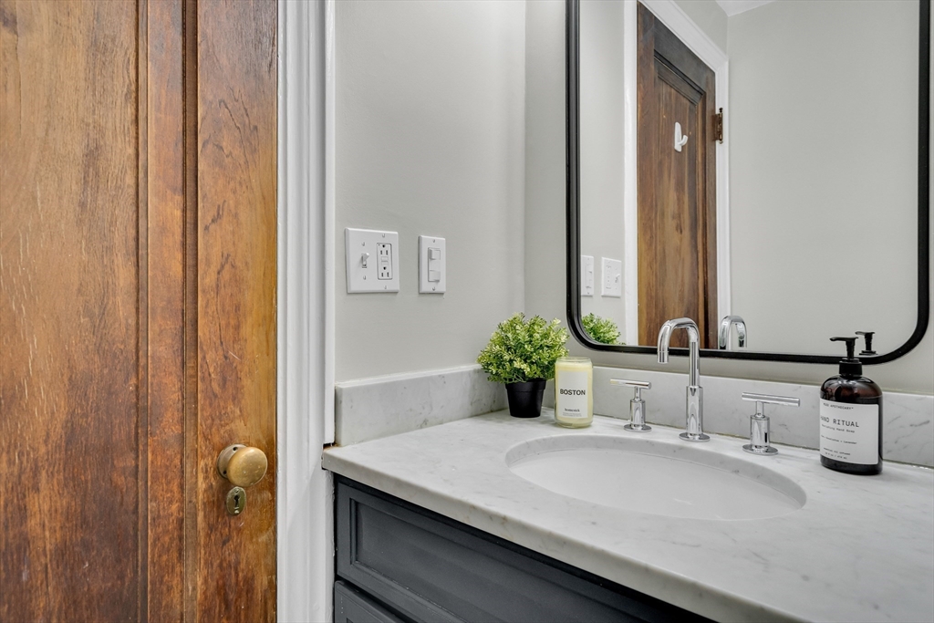 60 Charlesgate West, Unit BA Boston, MA 02215 - Photo 29 of 37 a bathroom with a granite countertop sink and a mirror