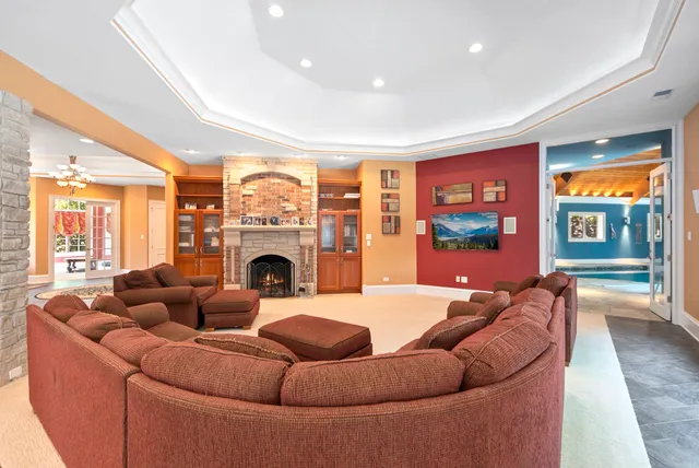 a living room with furniture a fireplace and a floor to ceiling window