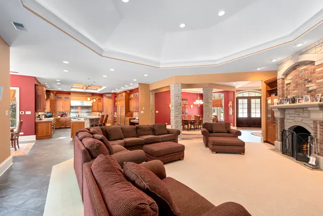 a living room with furniture fireplace and a large window