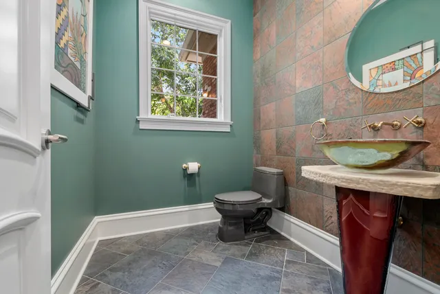 a bathroom with a toilet a sink and a mirror