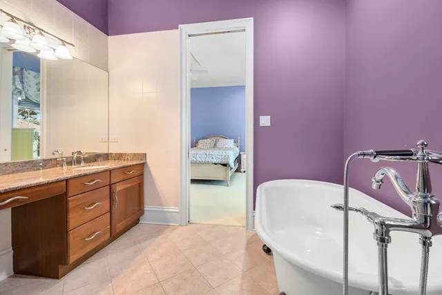 a en suite bathroom with a granite countertop sink and a mirror