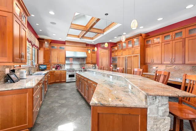 a large kitchen with kitchen island granite countertop a large window and a counter space