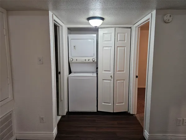 a view of a hallway with wooden floor and closet area