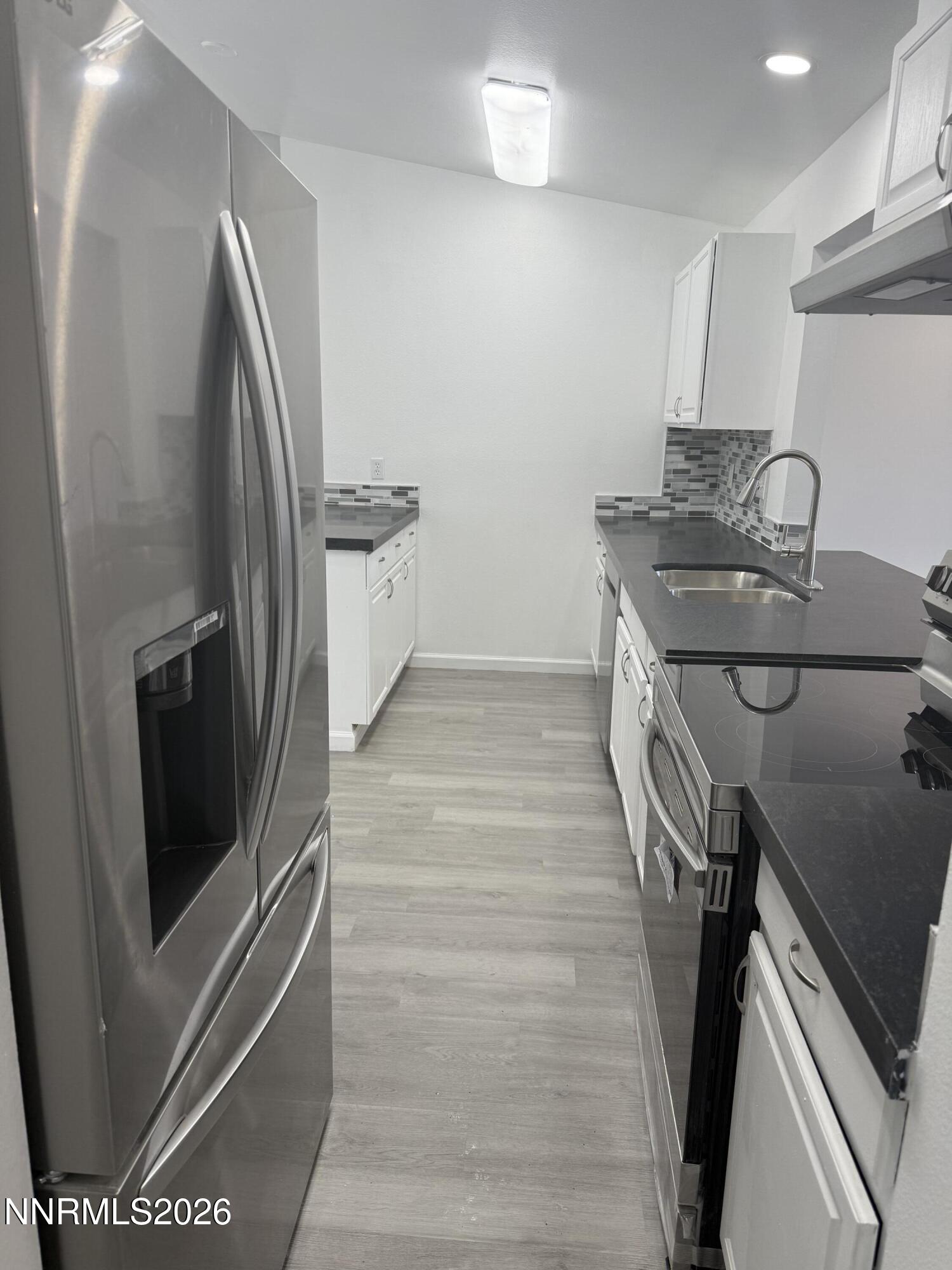 995 Sage View Drive Sparks, NV 89434 - Photo 4 of 13 a kitchen with stainless steel appliances granite countertop a sink a stove a refrigerator and a stove with wooden floor