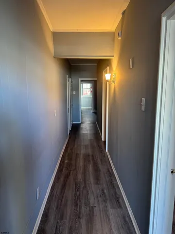 a view of a hallway with wooden floor and a wooden floor