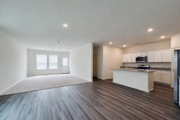 a kitchen with a refrigerator and a stove top oven