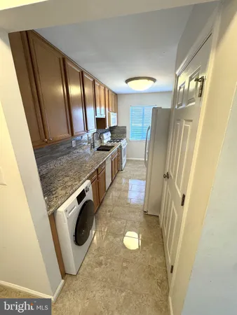a view of a kitchen with fridge and wooden floor