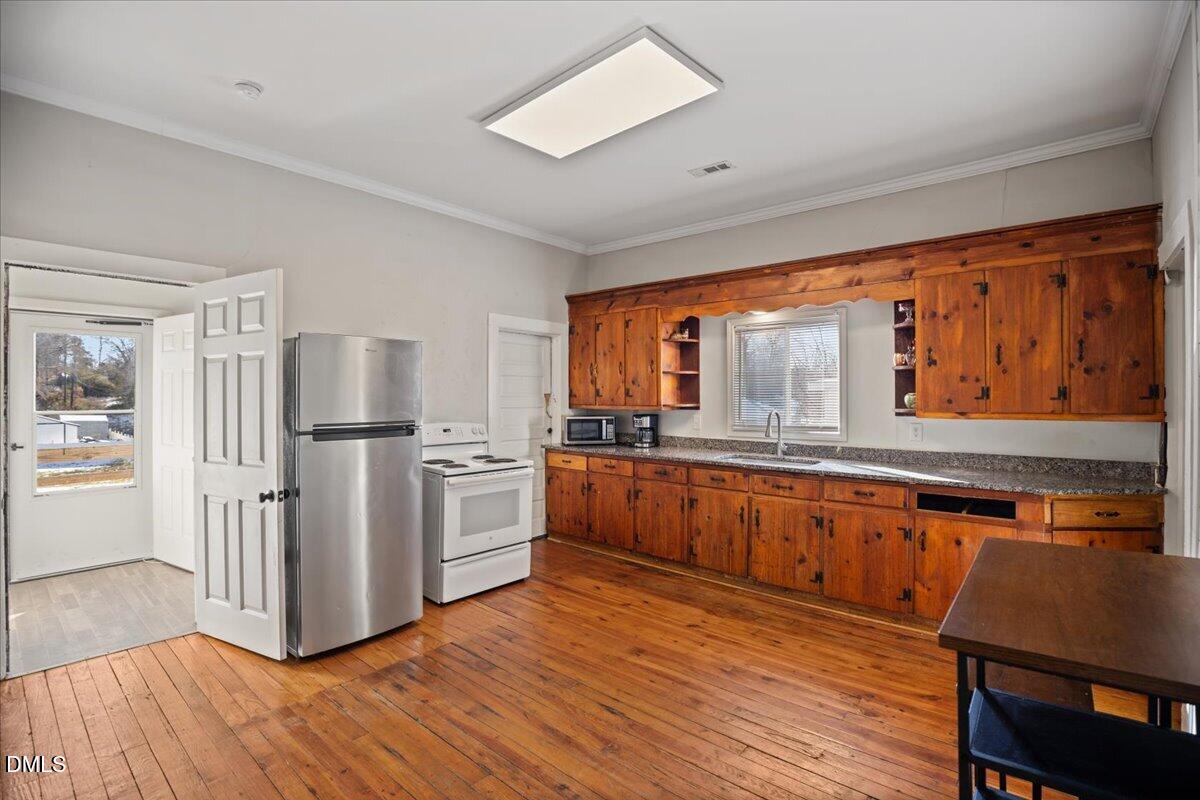 123 Kerr Drive Roxboro, NC 27573 - Photo 11 of 33 a kitchen with stainless steel appliances granite countertop a refrigerator a stove and a wooden floors