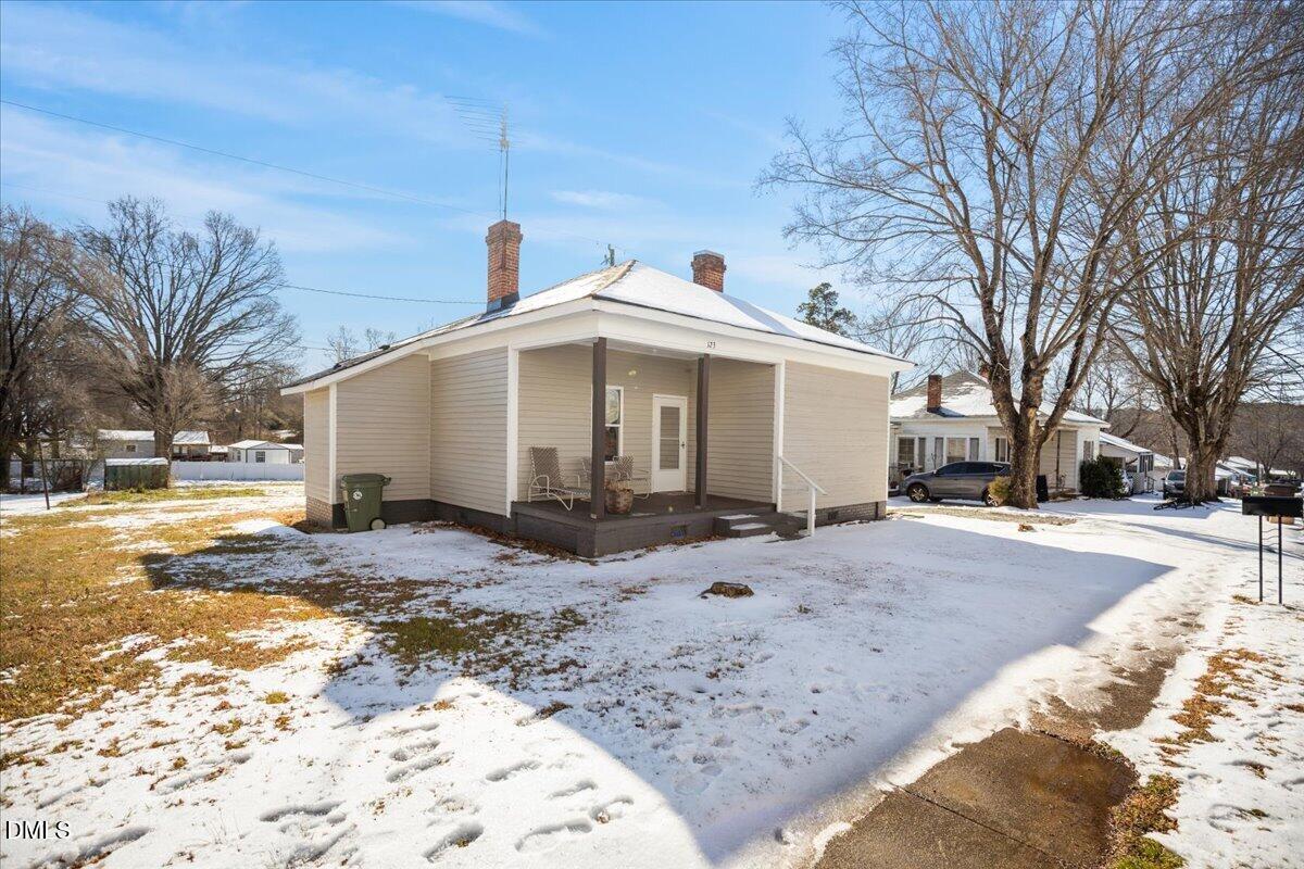 123 Kerr Drive Roxboro, NC 27573 - Photo 3 of 33 a view of a white house with a yard covered in snow