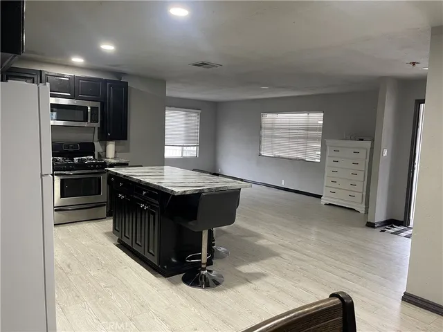 a kitchen with kitchen island a counter top space appliances and a window