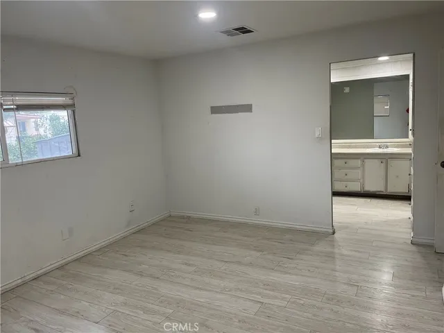 an empty room with a bathroom and mirror