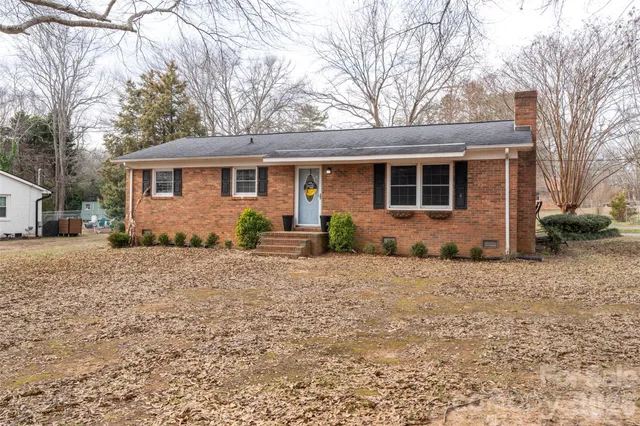 a front view of house with yard and trees around