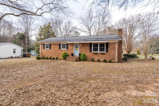 a front view of house with yard and trees around