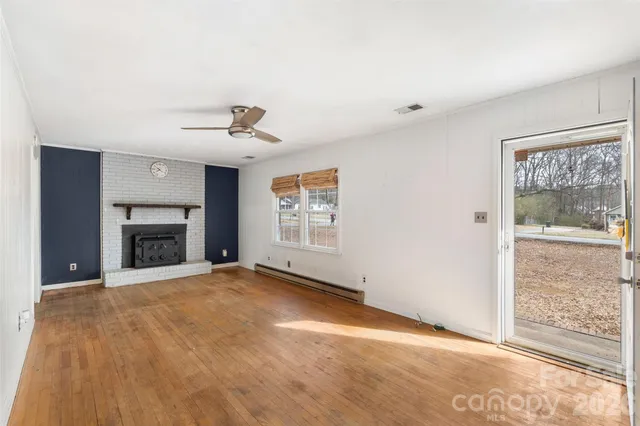 a view of an empty room with a fireplace and a window