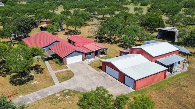 an aerial view of a house with pool and yard