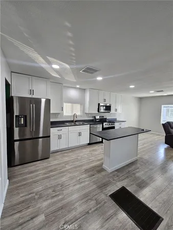 a large kitchen with a refrigerator and a stove top oven