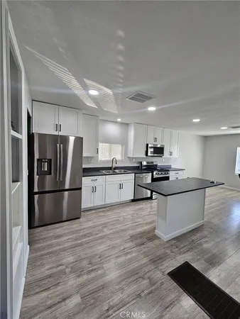 a large kitchen with a refrigerator and a sink