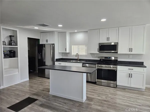 a kitchen with stainless steel appliances granite countertop a stove a refrigerator and a microwave