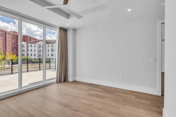 an empty room with wooden floor and windows