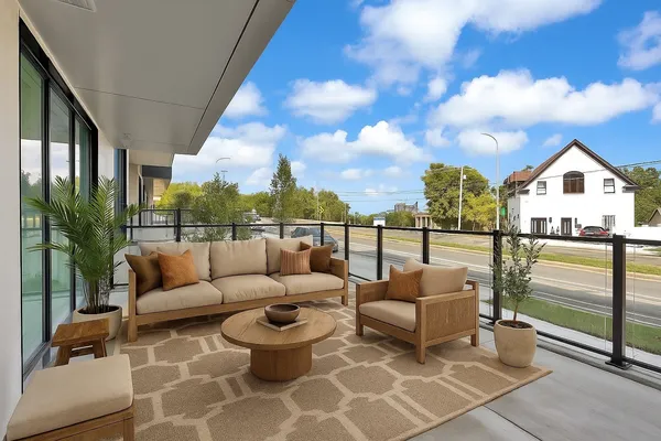 a balcony with furniture and a floor to ceiling window
