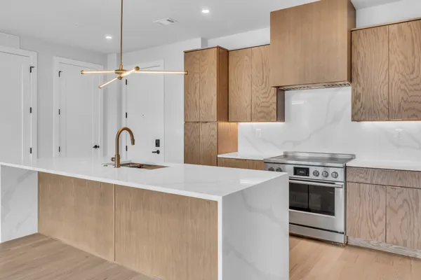 a kitchen with stainless steel appliances a stove a sink and white cabinets