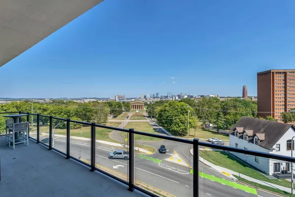 a large living room with stainless steel appliances granite countertop couches a fireplace with wooden floor