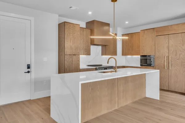 a kitchen with stainless steel appliances granite countertop a sink a refrigerator and a stove