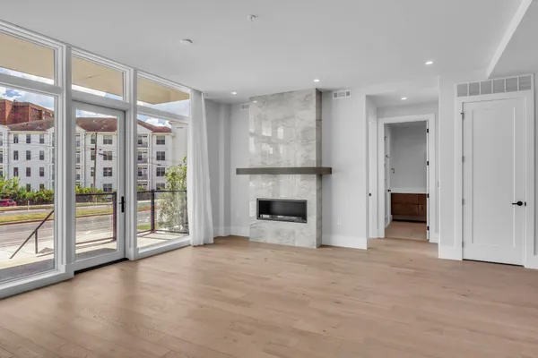 a view of a livingroom with wooden floor a fireplace and window