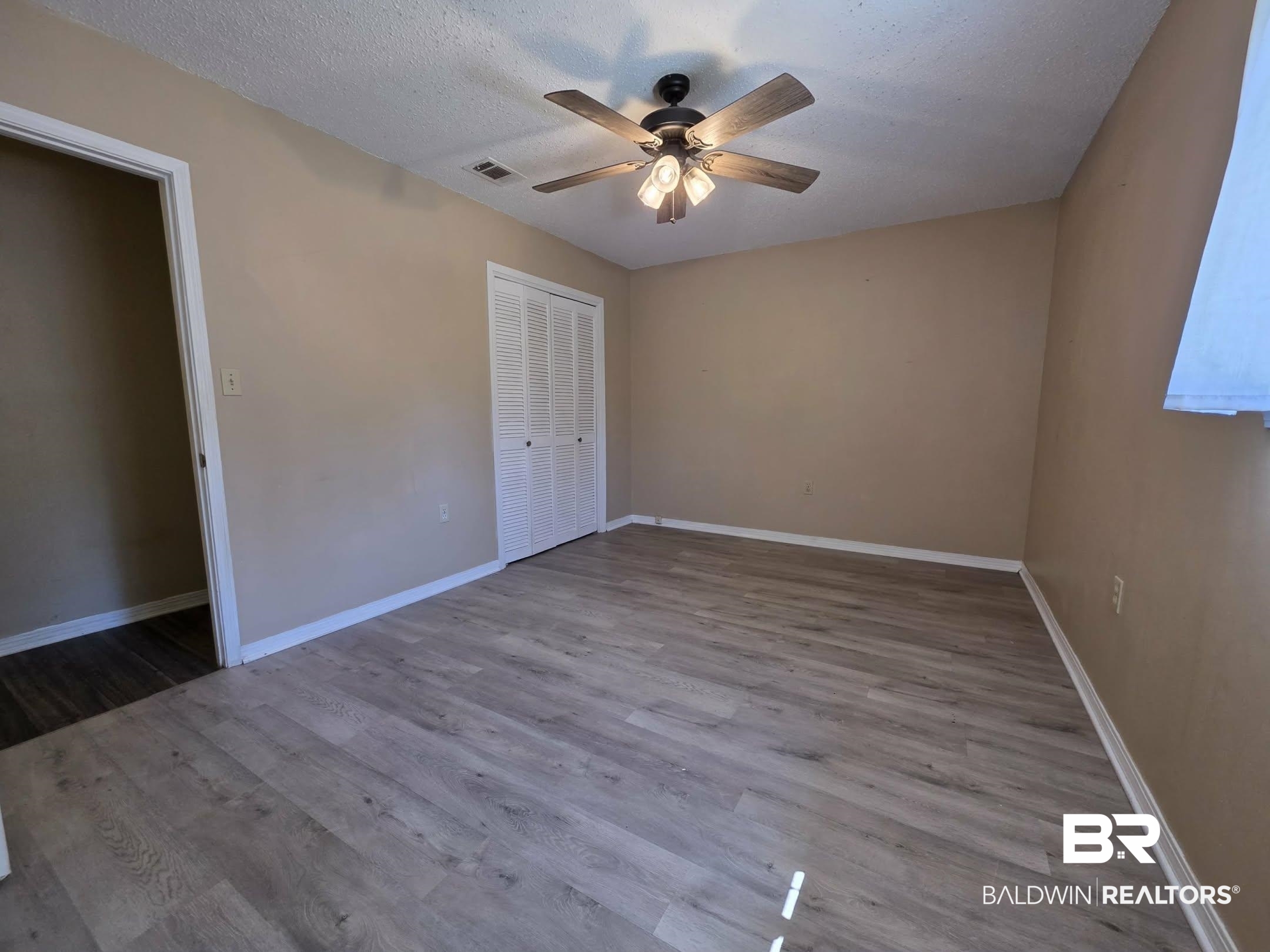 11 Coal Fire Road Jackson, AL 36545 - Photo 20 of 23 Unfurnished bedroom featuring wood finished floors, ceiling fan, a closet, and a textured ceiling