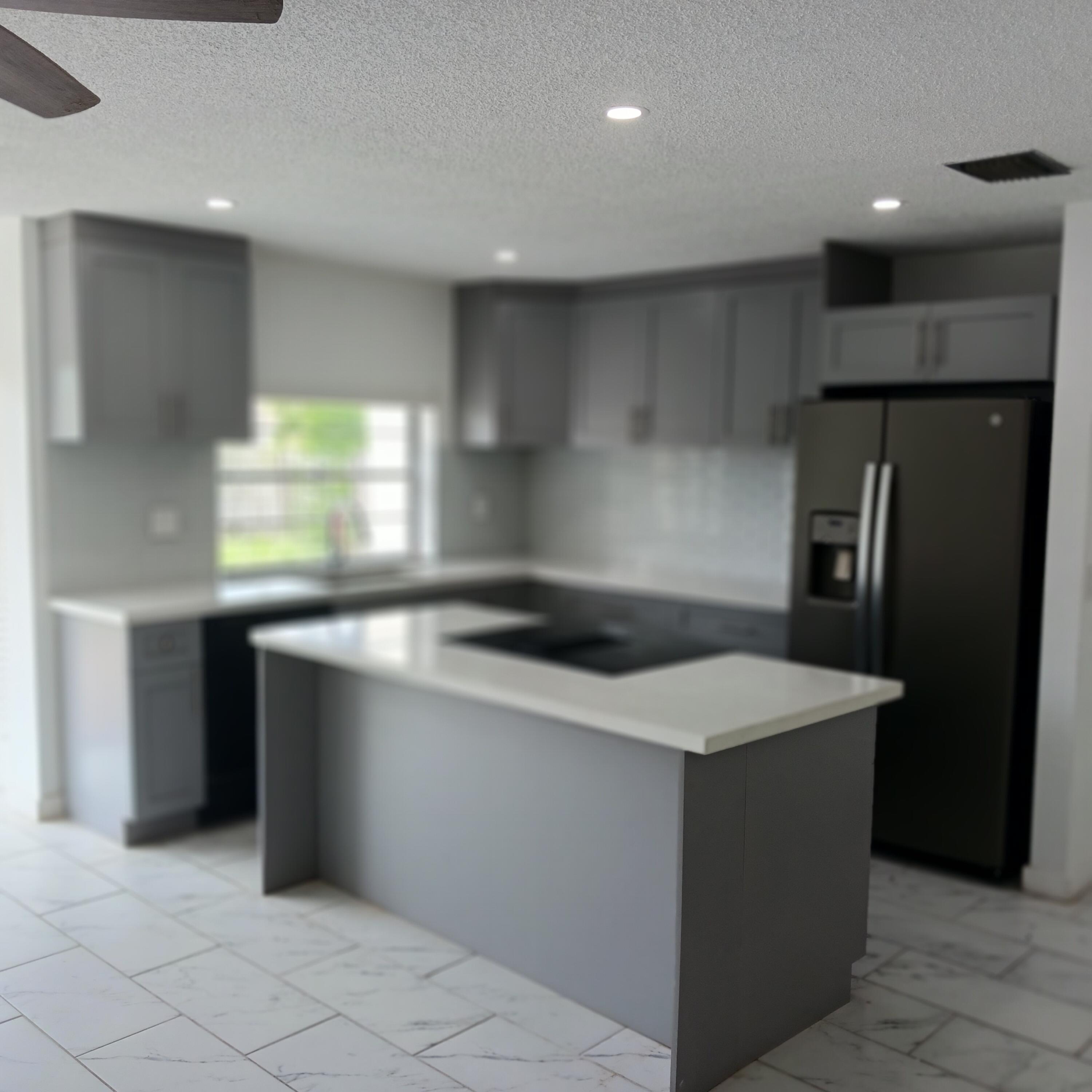 6533 Sweet Maple Lane Boca Raton, FL 33433 - Photo 4 of 20 a kitchen with stainless steel appliances a sink and a refrigerator