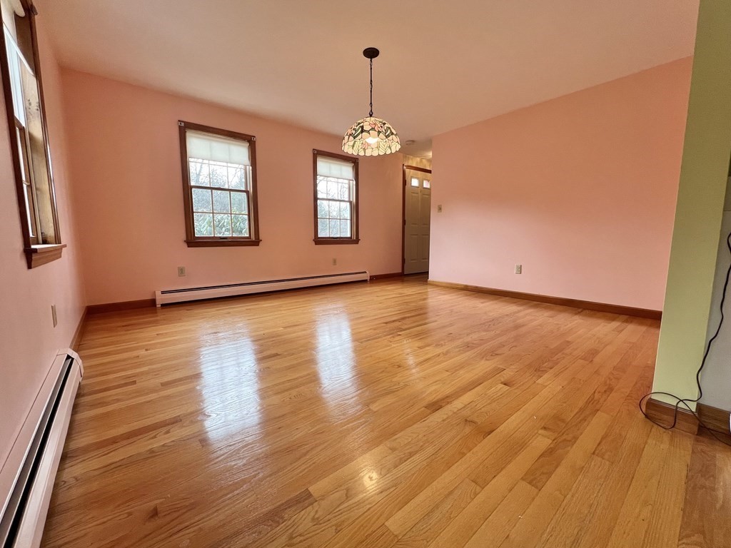 68 Deer Run Circle Barre, MA 01005 - Photo 9 of 26 an empty room with wooden floor chandelier and windows