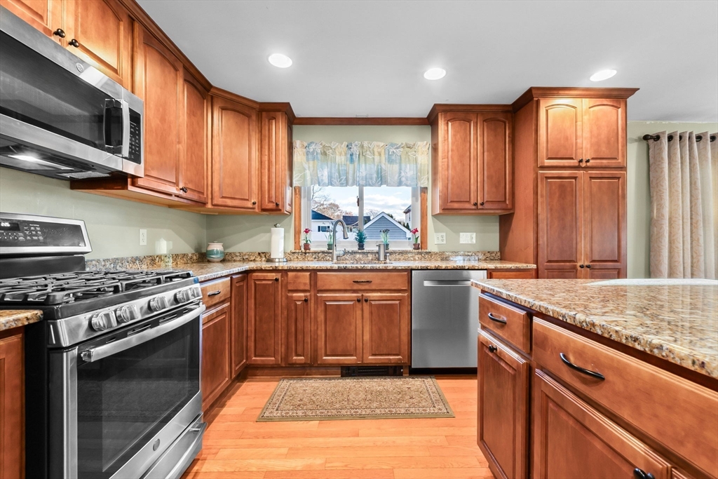 11 Wilson Avenue Wakefield, MA 01880 - Photo 15 of 42 a kitchen with stainless steel appliances granite countertop wooden cabinets a stove top oven a sink and dishwasher