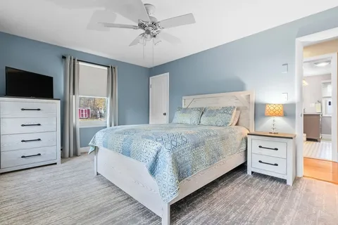 a spacious bedroom with a bed and a flat screen tv