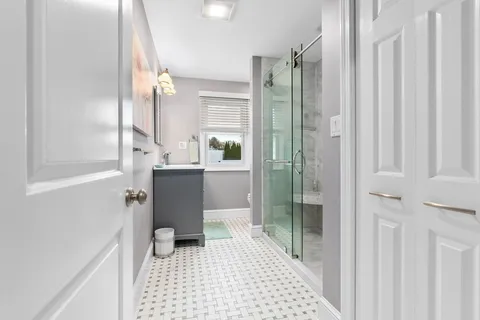 a bathroom with a sink a toilet a window and vanity