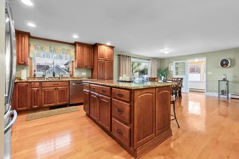 a kitchen with stainless steel appliances granite countertop sink stove and wooden cabinets