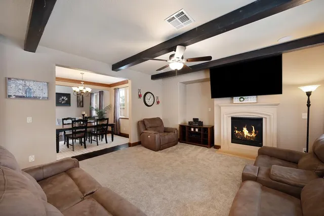 a living room with furniture a fireplace and a flat screen tv