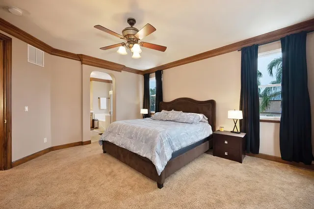 a bedroom with a large bed and a chandelier