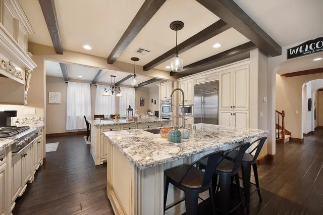 a kitchen with stainless steel appliances granite countertop a stove and a wooden floors