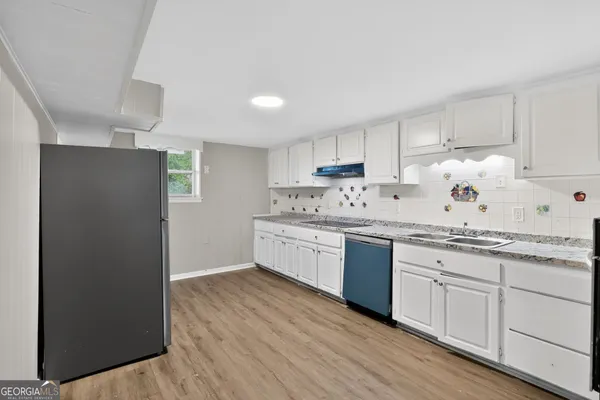 a kitchen with granite countertop white cabinets and white appliances