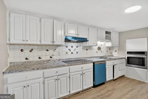 a kitchen with granite countertop cabinets and white stainless steel appliances
