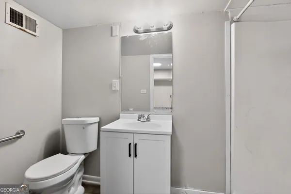 a bathroom with a sink mirror vanity and toilet