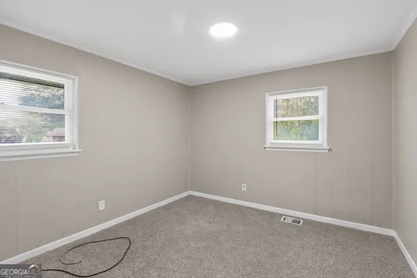 a room with window and white walls