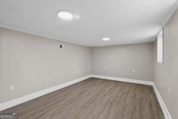 a view of an empty room with wooden floor