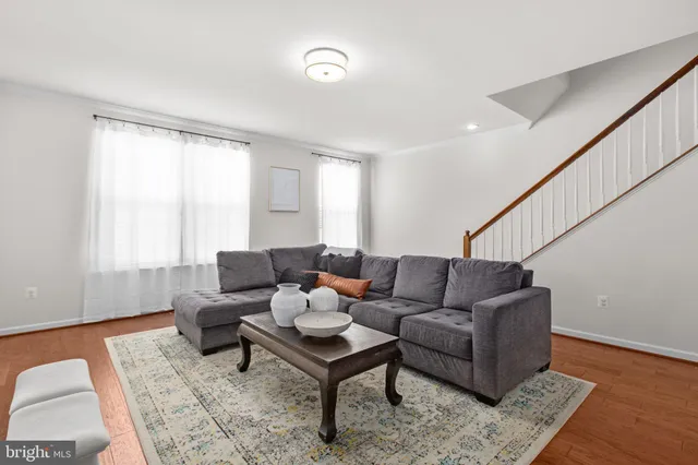 a living room with furniture wooden floor and a rug