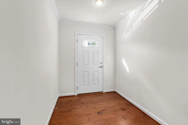 a view of an empty room with closet and a window