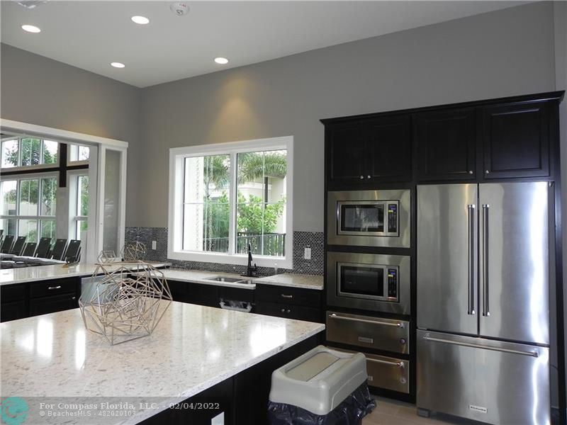 4350 Hillcrest Drive, Unit 212 Hollywood, FL 33021 - Photo 35 of 38 a kitchen with a refrigerator and windows